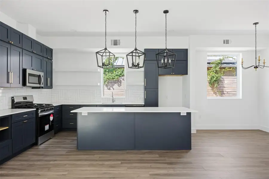 Kitchen with pendant lighting, decorative backsplash, a kitchen island, and open shelves Kitchen with pendant lighting, decorative backsplash, a kitchen island, and open shelves