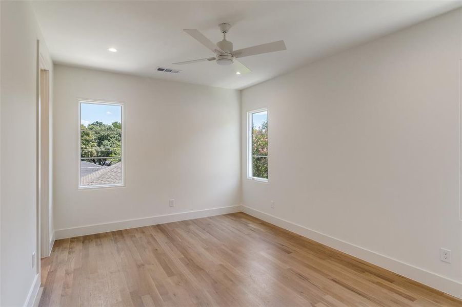 Empty room with light wood finished floors, recessed lighting, and ceiling fan Empty room with light wood finished floors, recessed lighting, and ceiling fan