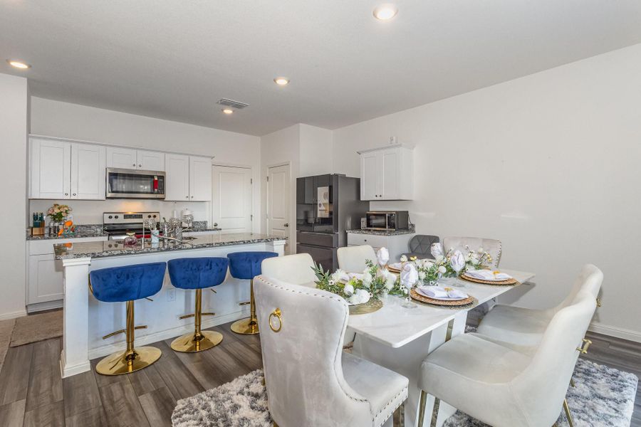 Kitchen featuring a center island with sink, white cabinets, and stainless steel appliances