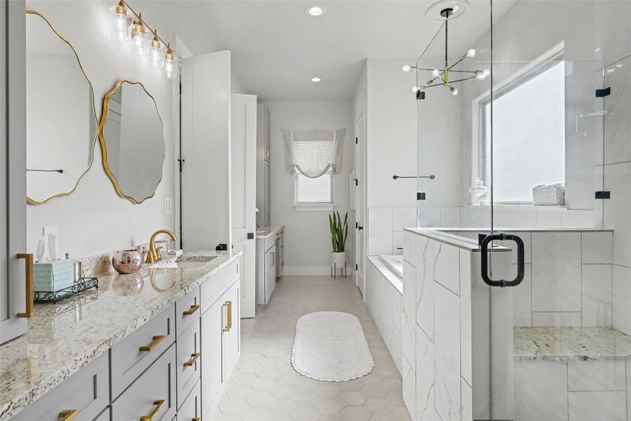 Primary bath featuring dual vanity, a shower stall, a bath, light tile patterned floors, and a chandelier