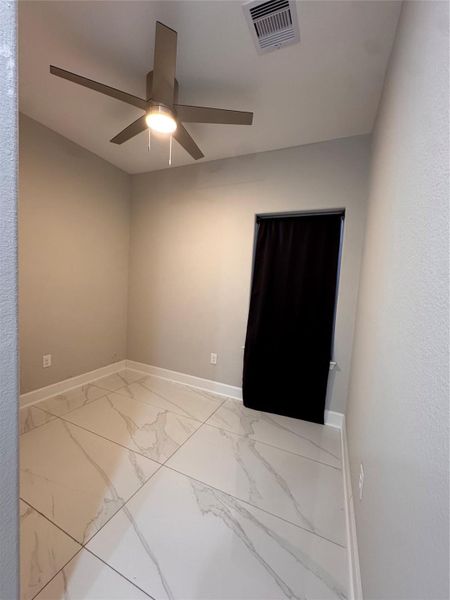 Bright room featuring sleek tile flooring, neutral walls, and a modern ceiling fan, perfect for a cozy and versatile space. Bright room featuring sleek tile flooring, neutral walls, and a modern ceiling fan, perfect for a cozy and versatile space.