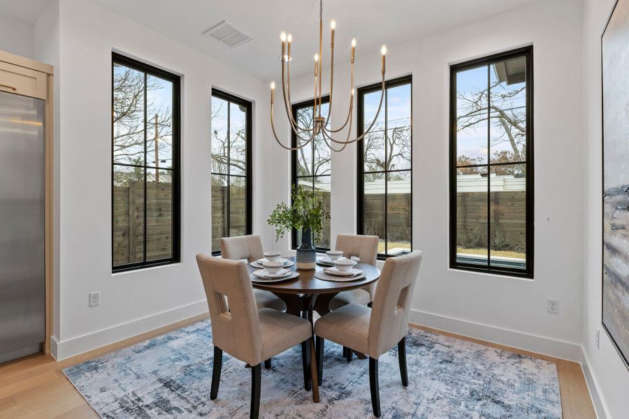 Dining space with a chandelier, light wood finished floors, and baseboards
