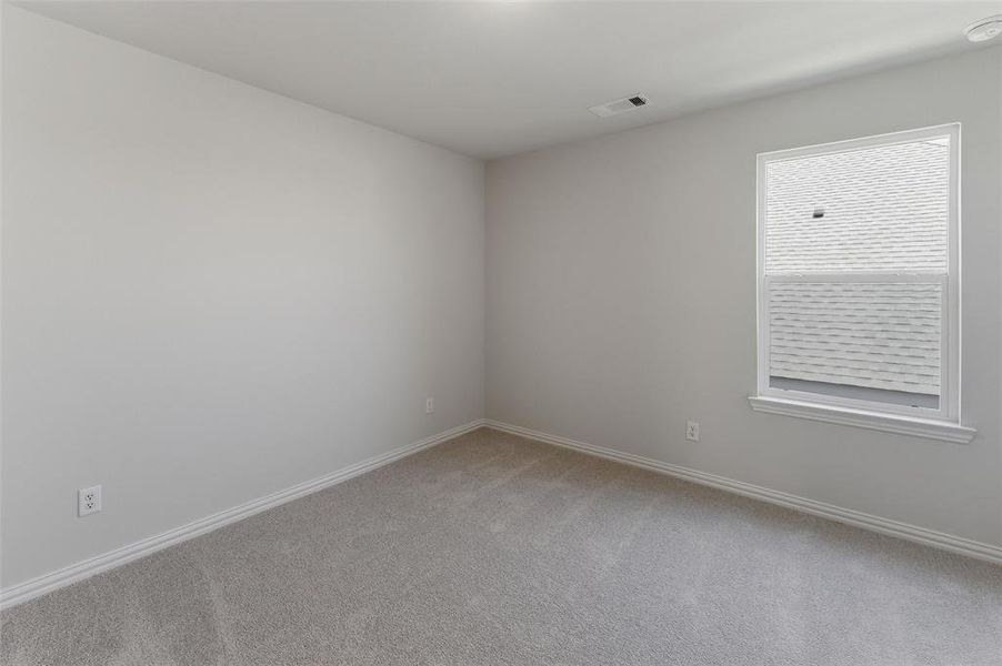 Carpeted room with a single window and light gray walls