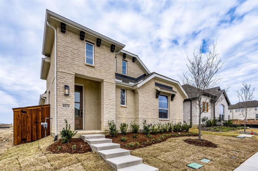 View of front facade featuring a gate, stone siding, and brick siding View of front facade featuring a gate, stone siding, and brick siding