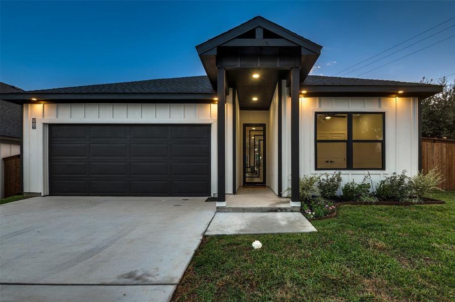 View of front of home featuring a front lawn and a garage