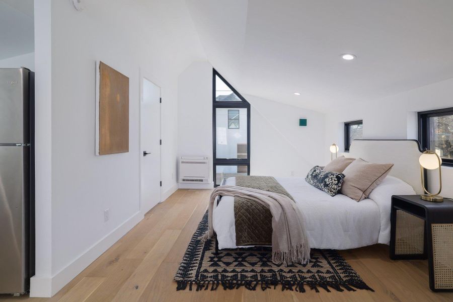Bedroom featuring freestanding refrigerator, light wood finished floors, and recessed lighting