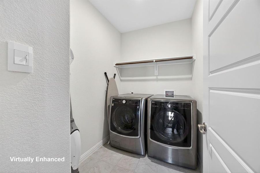 Laundry room featuring a textured wall and washing machine and clothes dryer