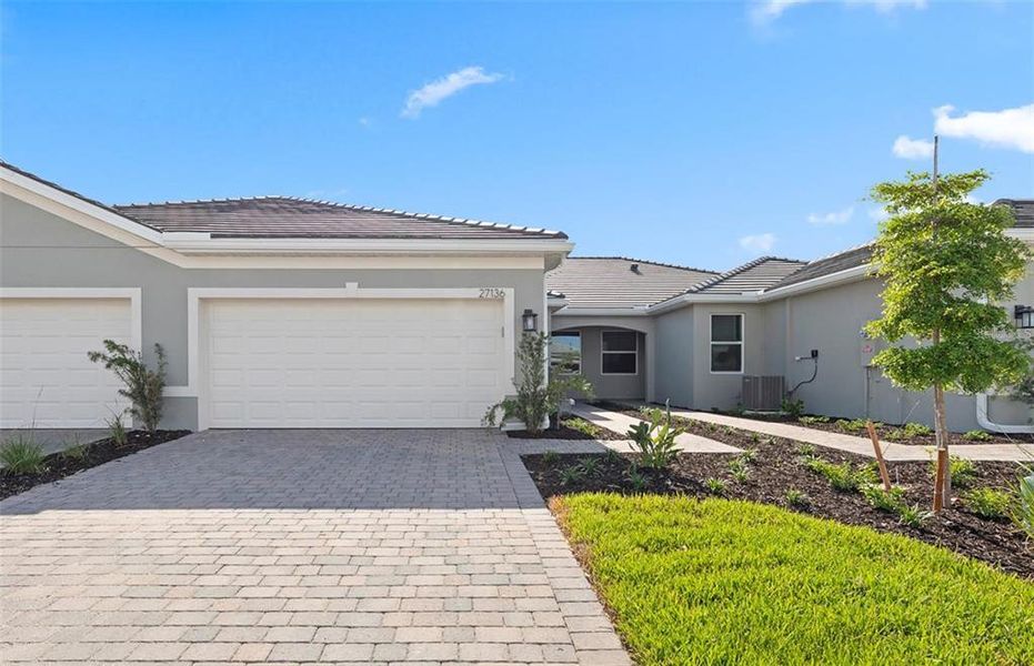 Front exterior of a new home in BeachWalk by Manasota Key, Englewood, FL, highlighting curb appeal (Image 2). Front exterior of a new home in BeachWalk by Manasota Key, Englewood, FL, highlighting curb appeal (Image 2).