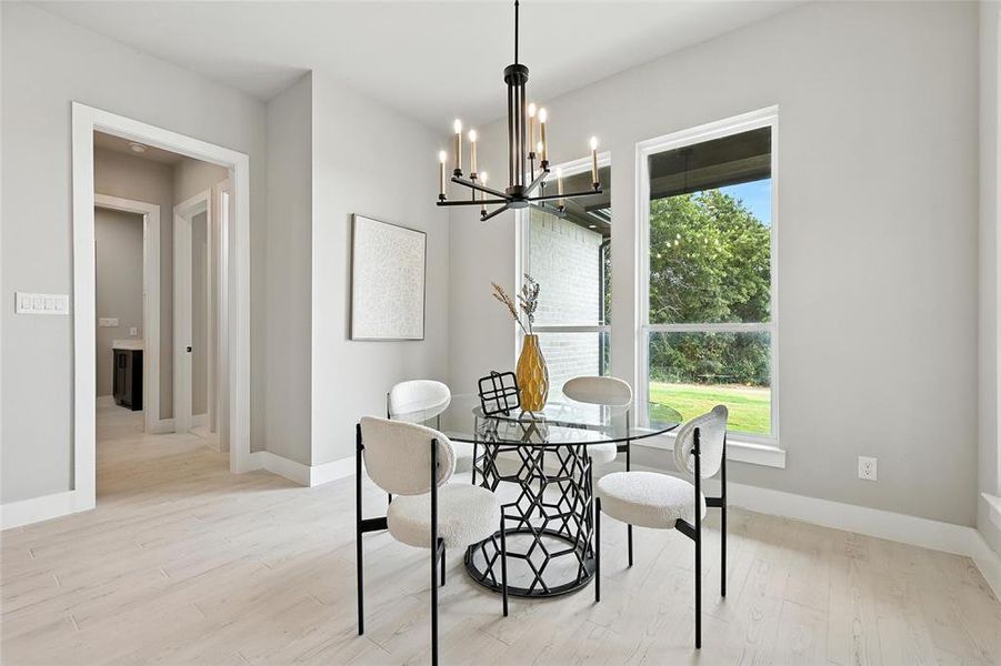 Dining space featuring plenty of natural light, a chandelier, and light wood finished floors