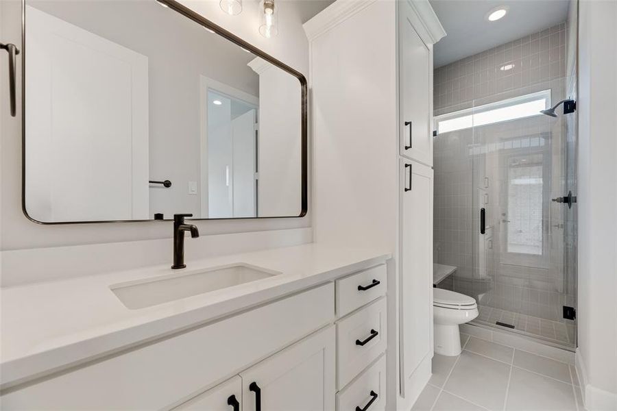 Bathroom featuring vanity, a shower stall, light tile patterned floors, and recessed lighting