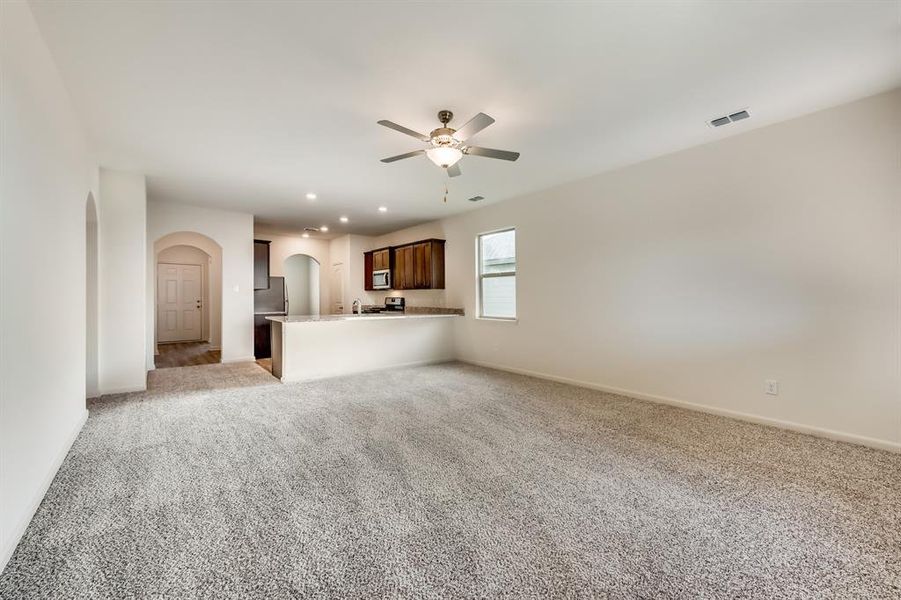 Living room with light carpet and ceiling fan