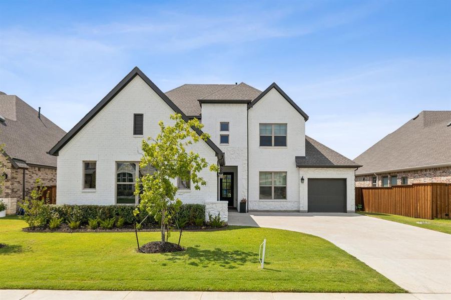 View of front of property featuring a garage and a front yard