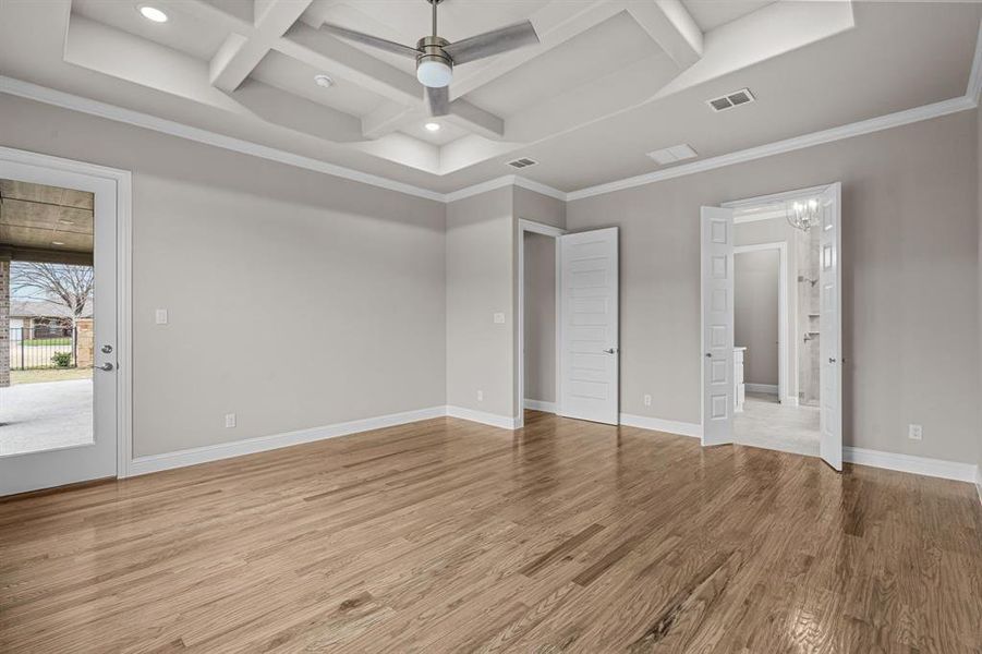 Unfurnished bedroom with crown molding, coffered ceiling, beam ceiling, and light hardwood / wood-style floors. Not actual home. Previous built example.