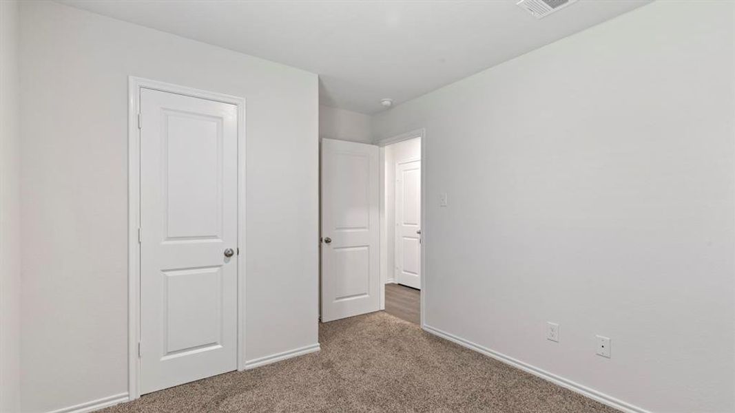 Carpeted room with white walls, white trim, and white doors