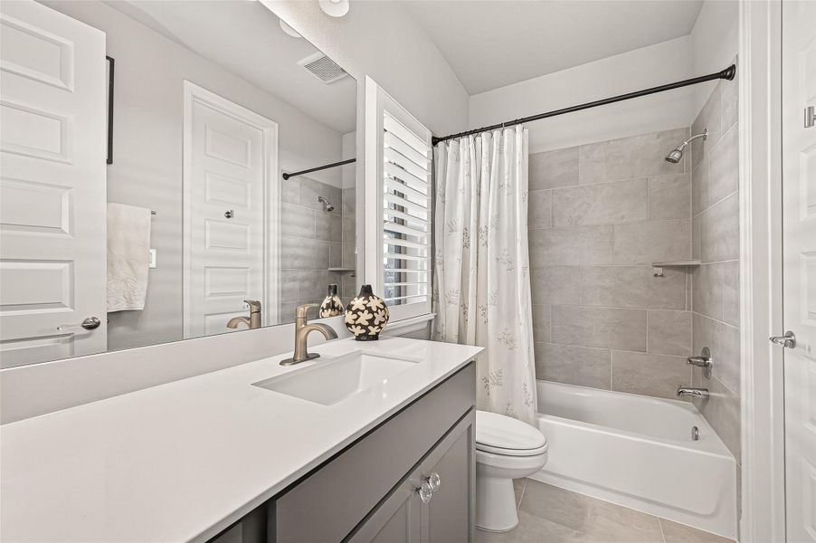 Private ensuite bathroom for the front bedroom, functioning as a third full bath and offering a perfect configuration for visiting guests or multi-generational households. (Note: Photo is staged; property is currently vacant.) Private ensuite bathroom for the front bedroom, functioning as a third full bath and offering a perfect configuration for visiting guests or multi-generational households. (Note: Photo is staged; property is currently vacant.)