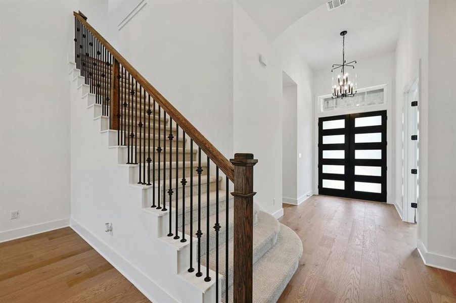 Foyer entrance featuring light wood-type flooring and a chandelier Foyer entrance featuring light wood-type flooring and a chandelier