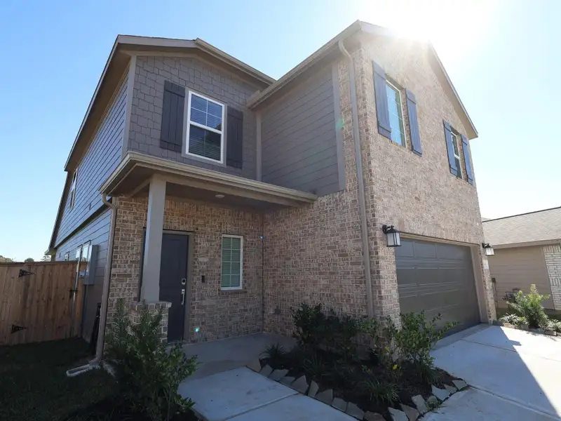 Front exterior of a new home in Pinewood at Grand Texas, New Caney, TX, highlighting curb appeal (Image 2).