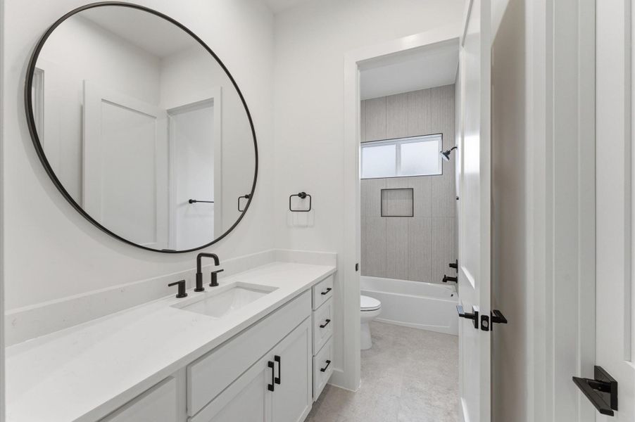 Secondary bathroom with quartz countertops and privacy door to tub/shower combo.