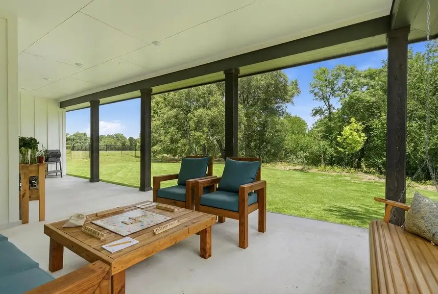 A spacious covered patio provides a serene setting overlooking a verdant lawn and natural surroundings. A spacious covered patio provides a serene setting overlooking a verdant lawn and natural surroundings.