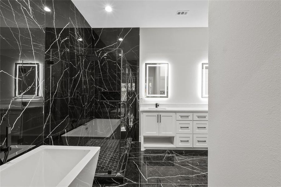 Bathroom featuring separate shower and tub and vanity