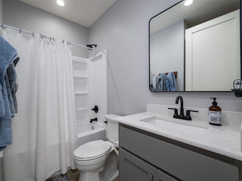 Bathroom with shower / tub combo with curtain, vanity, and recessed lighting Bathroom with shower / tub combo with curtain, vanity, and recessed lighting