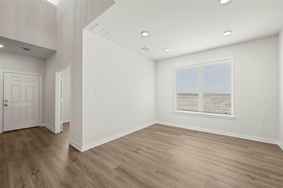 A well-lit room showcases high ceilings and durable hardwood flooring.