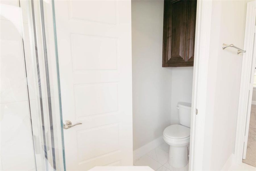 Primary Bathroom with tile patterned flooring and toilet