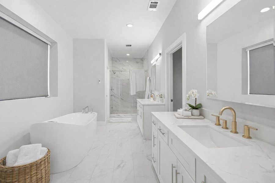 Bathroom featuring two vanities, a marble finish shower, light marble finish floors, a soaking tub, and recessed lighting