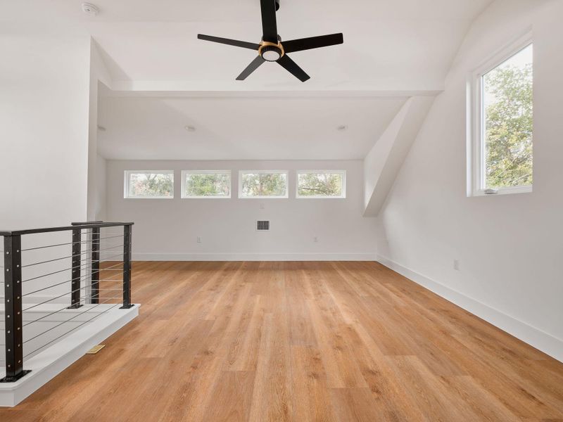 Bonus room featuring light wood-type flooring and a ceiling fan Bonus room featuring light wood-type flooring and a ceiling fan