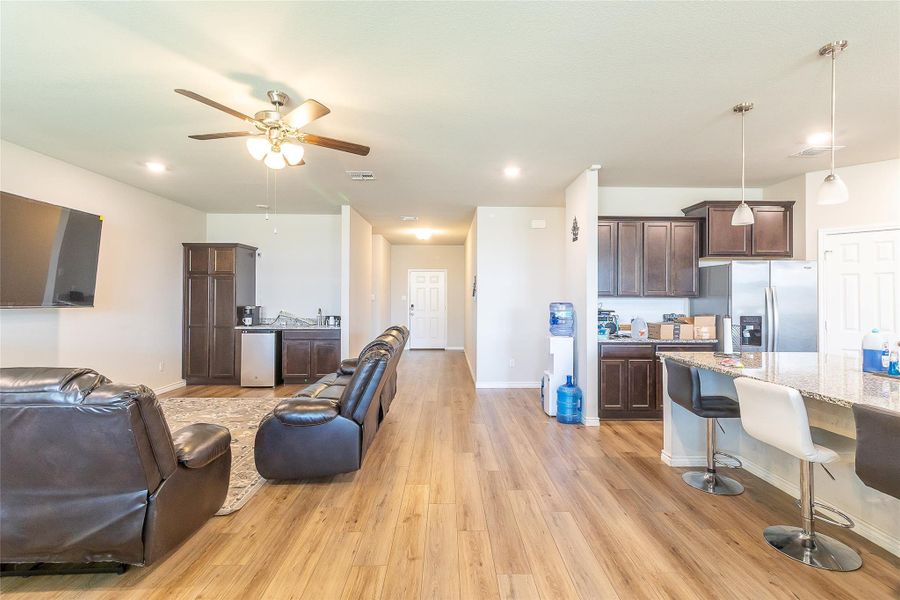 An open floor plan seamlessly connects the kitchen and living area, featuring rich wood cabinetry and ample counter space. An open floor plan seamlessly connects the kitchen and living area, featuring rich wood cabinetry and ample counter space.