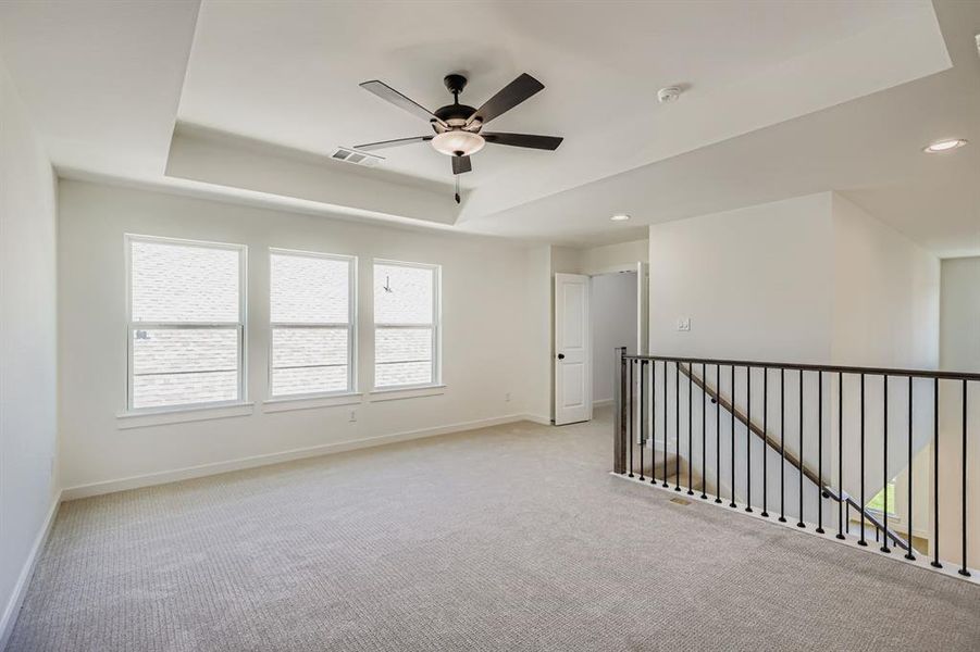 Empty room with carpet floors, a tray ceiling, a ceiling fan, and recessed lighting