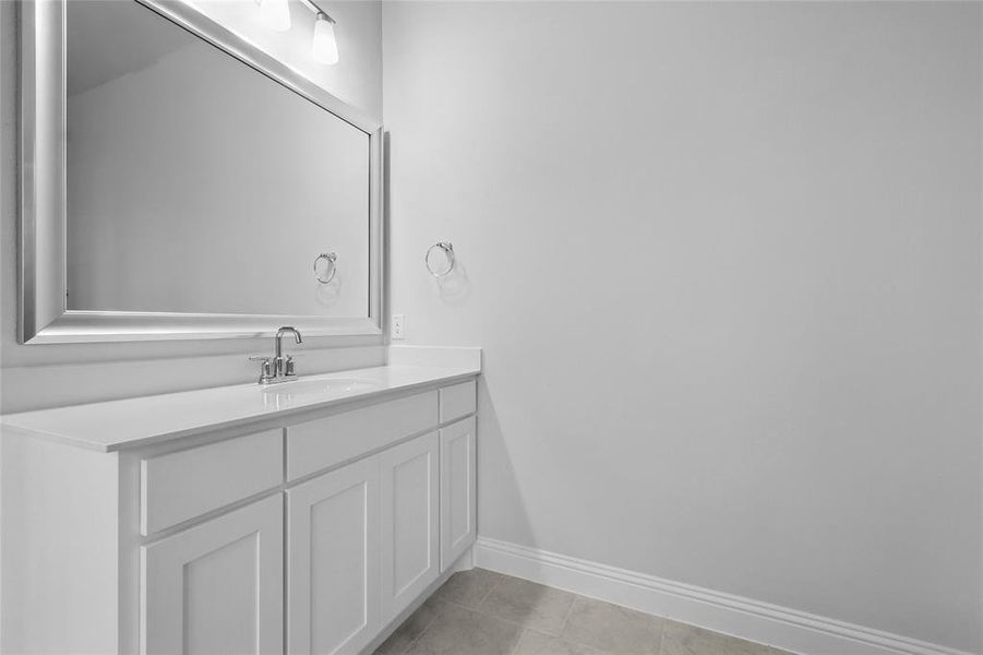 Bathroom with baseboards, vanity, and tile patterned flooring Bathroom with baseboards, vanity, and tile patterned flooring