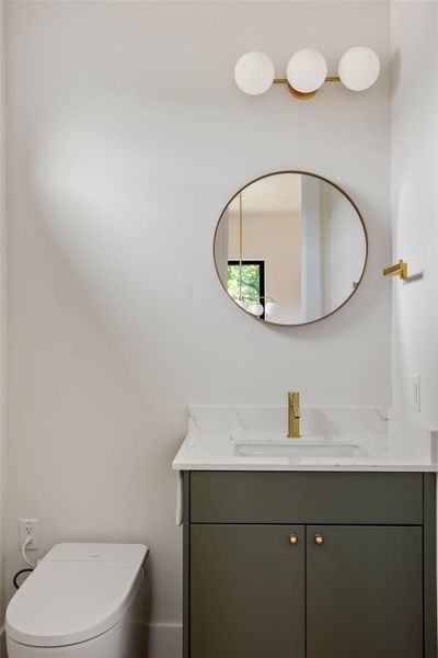 Half bath featuring vanity and toilet Half bath featuring vanity and toilet