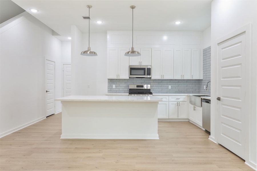 Start your day effortlessly with this spacious island surrounded by a sea of luxury wood plank LVP flooring.