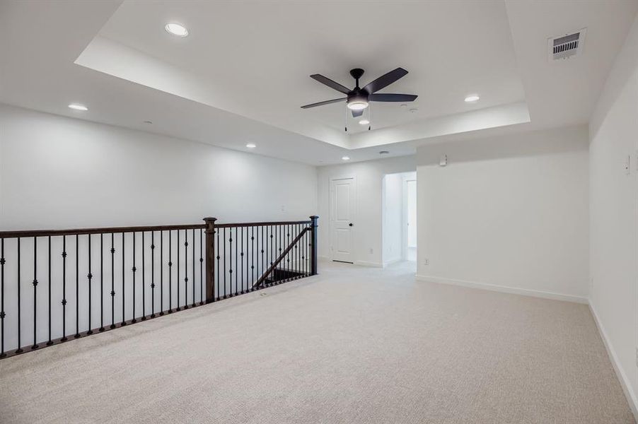 Unfurnished room featuring a raised ceiling, light colored carpet, a ceiling fan, and recessed lighting Unfurnished room featuring a raised ceiling, light colored carpet, a ceiling fan, and recessed lighting