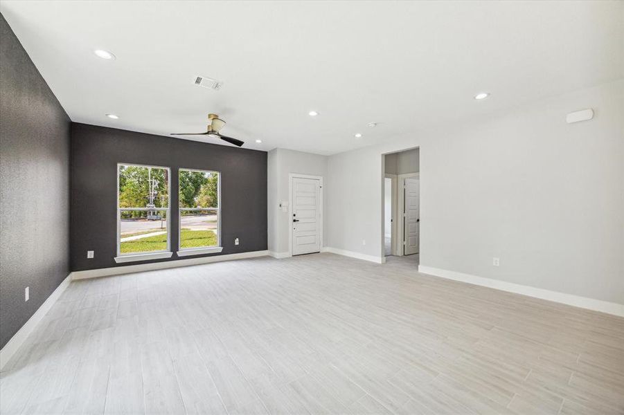 View of the spacious living area, receiving an abundance of natural light from the expansive front windows