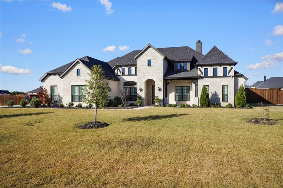 French country inspired facade featuring stone siding, a chimney, and a shingled roof French country inspired facade featuring stone siding, a chimney, and a shingled roof