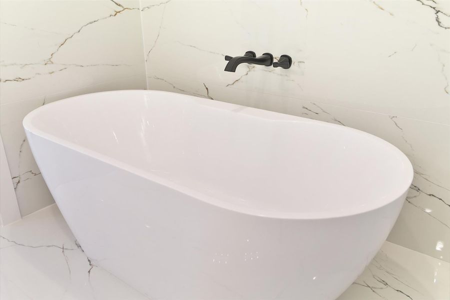 Relax in your luxurious soaking tub, complemented by a sleek wall-mounted modern faucet for a refined touch. Relax in your luxurious soaking tub, complemented by a sleek wall-mounted modern faucet for a refined touch.