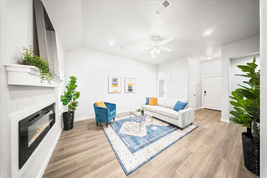 Living room featuring a glass covered fireplace, light wood-type flooring, ceiling fan, and recessed lighting Living room featuring a glass covered fireplace, light wood-type flooring, ceiling fan, and recessed lighting