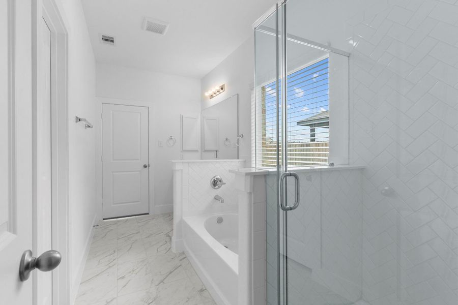 Luxurious primary bath with a glass-enclosed massive shower, and elegant tile floors for a true spa experience. (This home has a shower only)**Image Representative of Plan Only and May Vary as Built**.