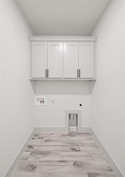 Washroom with gas dryer hookup, light wood-style flooring, electric dryer hookup, hookup for a washing machine, and cabinet space Washroom with gas dryer hookup, light wood-style flooring, electric dryer hookup, hookup for a washing machine, and cabinet space