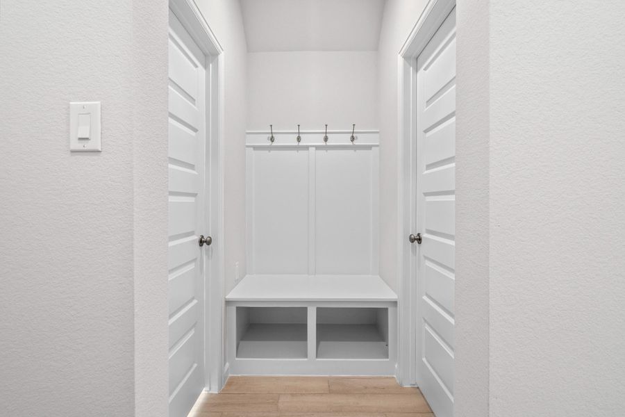 Built-in mudroom-style drop zone with bench, hooks and storage near the home's everyday entry.