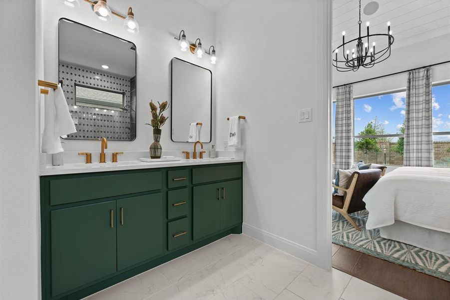 Ensuite bathroom featuring double vanity, light marble finish floors, and a chandelier Ensuite bathroom featuring double vanity, light marble finish floors, and a chandelier