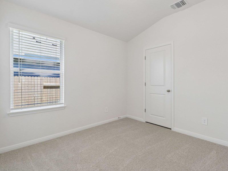 Soft carpeting underfoot and a large window create a serene setting in this versatile bedroom.