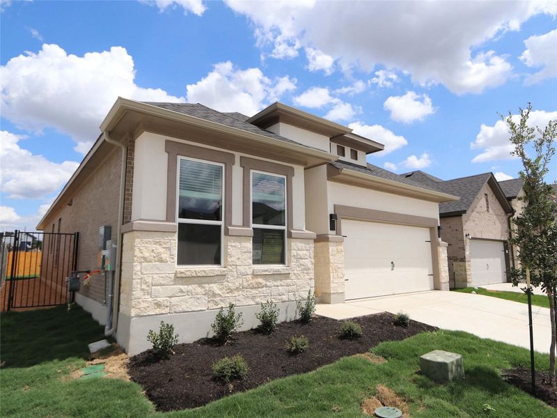 Front exterior of a new home in Estancia West, Manchaca, TX, highlighting curb appeal (Image 2). Front exterior of a new home in Estancia West, Manchaca, TX, highlighting curb appeal (Image 2).