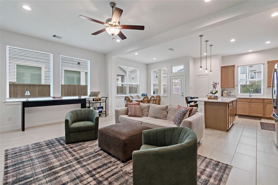 Spacious open-concept living area with abundant natural light, featuring a cozy seating arrangement, modern kitchen with island, and elegant dining space. Spacious open-concept living area with abundant natural light, featuring a cozy seating arrangement, modern kitchen with island, and elegant dining space.