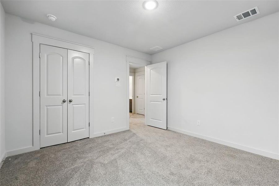 Unfurnished bedroom with carpet flooring and a closet