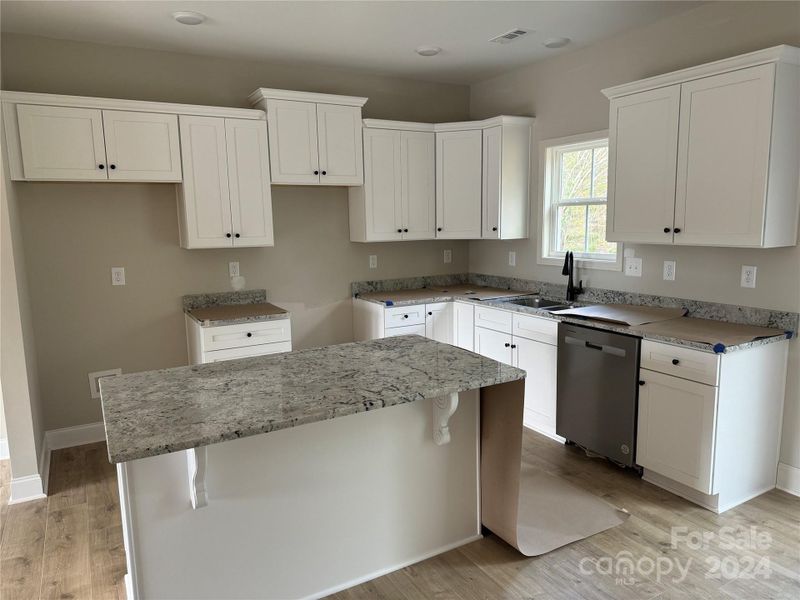 Kitchen with upgraded granite countertops, stainless appliances and dovetailed, soft close cabinetry