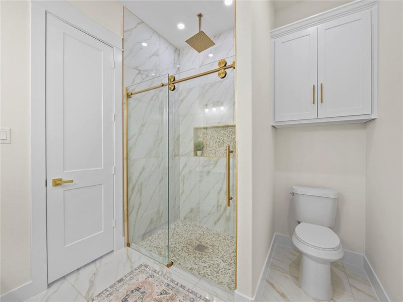 Full bath with a marble finish shower, light marble finish floors, and recessed lighting