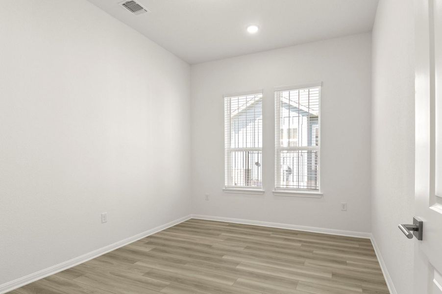 Empty room with light wood-style flooring and recessed lighting